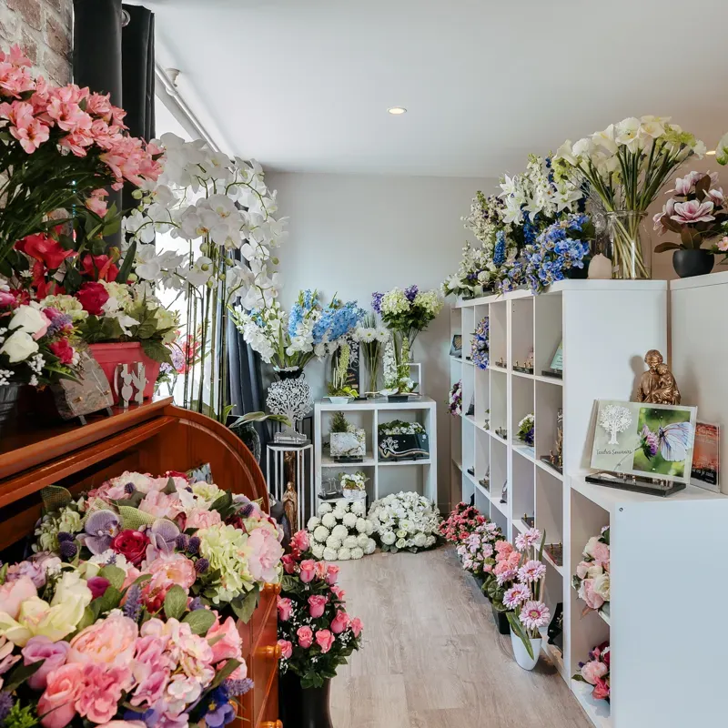 Magasin de fleurs et d'articles funéraires avec étagères d'exposition.